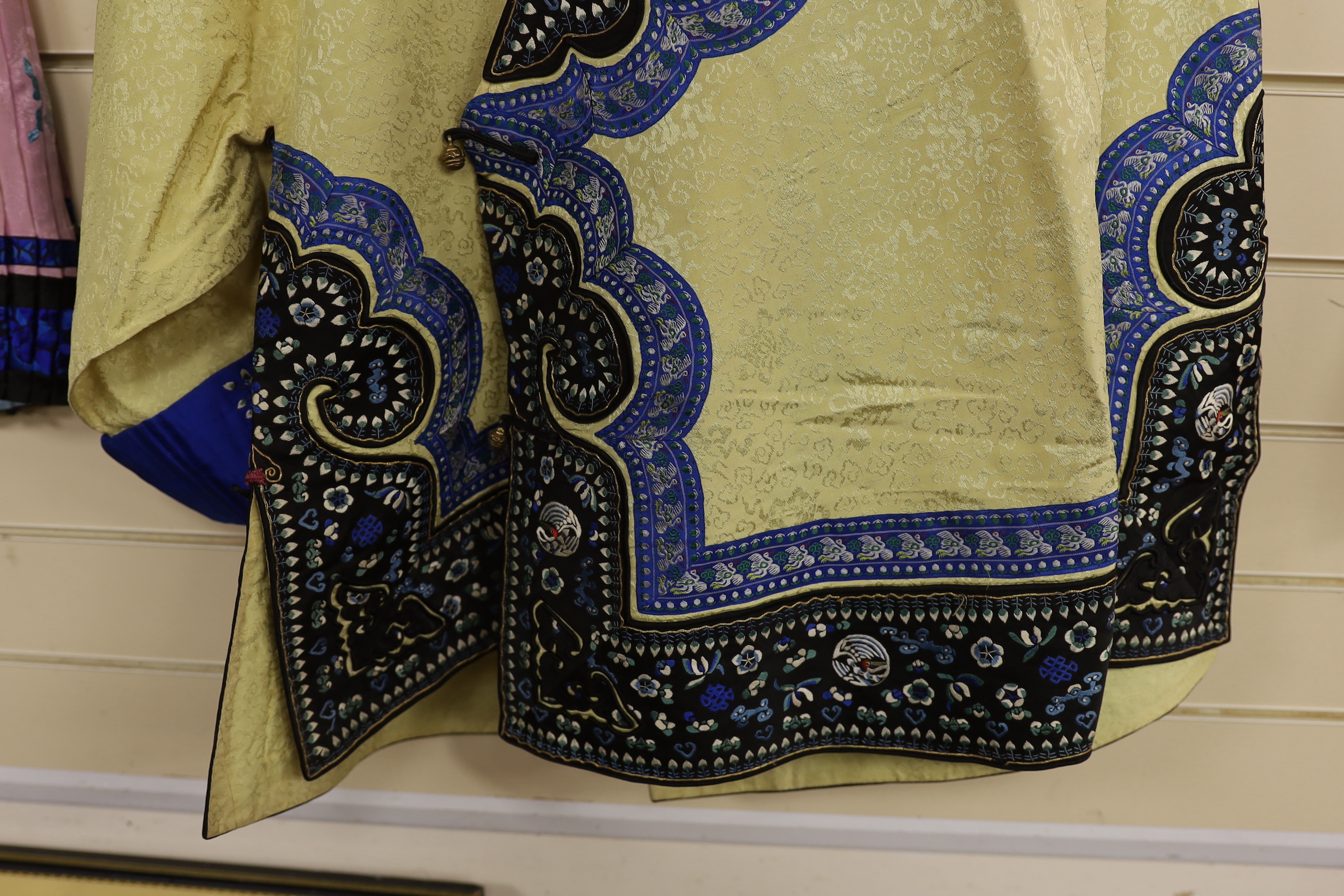 A Chinese late 19th century / early 20th century pale yellow silk damask embroidered robe and an earlier similar skirt embroidered with front panels of flowers and birds